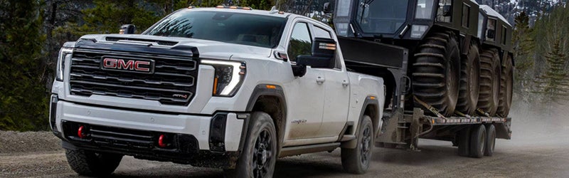 2026 GMC Sierra 3500 HD towing heavy equipment on a gooseneck trailer